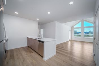 A kitchen with white cabinets and a wooden floor.